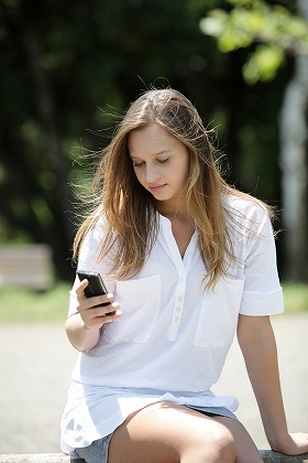 座ってメールする女性 mobile ロングヘア m010051